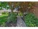 A beautifully landscaped backyard features a stone path leading to a seating area with greenery and mature trees at 1738 Pathway S Dr, Greenwood, IN 46143