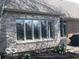 Exterior stone facade with flower garden and a view of large window and a statue at 1738 Pathway S Dr, Greenwood, IN 46143