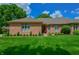 Charming single-story brick home featuring a well-manicured lawn, mature trees and inviting curb appeal at 1738 Pathway S Dr, Greenwood, IN 46143