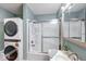 Bright bathroom features stackable washer and dryer, shower over tub and updated vanity at 1828 Central Ave, Columbus, IN 47201