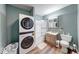 A full bathroom featuring a stacked washer/dryer, tub/shower combo, vanity and toilet at 1828 Central Ave, Columbus, IN 47201