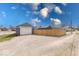 View of a gravel driveway and garage with a white door, situated adjacent to a wooden fence at 1828 Central Ave, Columbus, IN 47201