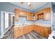 A well-lit kitchen boasts wood cabinets, durable countertops, stainless steel sink, and wood grain flooring at 1828 Central Ave, Columbus, IN 47201