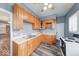 A well-lit kitchen boasts wood cabinets, durable countertops, stainless steel sink, and wood grain flooring at 1828 Central Ave, Columbus, IN 47201