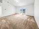 Spacious room with neutral walls and carpet, leading to a sliding glass door with backyard access at 1914 Kingen Dr, Greenfield, IN 46140