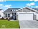 Charming home featuring stone accents, a gray roof, and a two-car garage, complemented by a well-maintained lawn at 19599 Atwater Ave, Sheridan, IN 46069