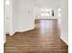 View of hardwood floors leading to a brightly lit room through an open hallway with a bathroom to the left at 19599 Atwater Ave, Sheridan, IN 46069
