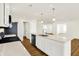Modern kitchen featuring a large island with quartz countertops, stainless steel appliances, and wood floors at 19599 Atwater Ave, Sheridan, IN 46069