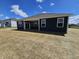 New construction house with a dark exterior, large windows, covered patio and a large backyard with freshly laid straw at 2254 Oakmont Dr, Plainfield, IN 46168