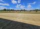 Large backyard featuring a layer of straw over the grass, framed by a fence and lush trees in the distance at 2254 Oakmont Dr, Plainfield, IN 46168