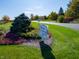 Avon Gardens entrance with colorful flowers, lush greenery, and welcoming signage for this lovely community at 2254 Oakmont Dr, Plainfield, IN 46168