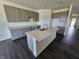 Bright kitchen boasts a central island, granite countertops, ample storage, gray cabinets, and dark hardwood floors at 2254 Oakmont Dr, Plainfield, IN 46168
