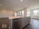 Open-concept kitchen island features a stainless steel dishwasher, double sink, and light gray cabinets at 2254 Oakmont Dr, Plainfield, IN 46168