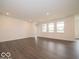 Spacious living room with wood-look flooring, white walls, and large windows at 2254 Oakmont Dr, Plainfield, IN 46168