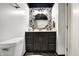 Stylish bathroom featuring a dark vanity with a vessel sink, round mirror, and elegant decor at 230 E 9Th St # Apt 405, Indianapolis, IN 46204