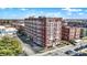 Aerial view of a brick building with white trimmed windows and a parking lot in an urban neighborhood at 230 E 9Th St # Apt 405, Indianapolis, IN 46204