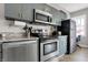 Apartment kitchen featuring stainless steel appliances, grey cabinetry, and granite countertops at 230 E 9Th St # Apt 405, Indianapolis, IN 46204