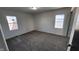 An ample bedroom features neutral carpeting and a pair of bright, natural-light-filled windows at 2317 Courtney Rd, Indianapolis, IN 46219