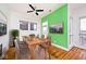 Bright dining room featuring modern ceiling fan, wood flooring, and green accent wall at 233 E St Joseph St # 3H, Indianapolis, IN 46202