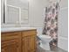 Bathroom with wooden cabinets, a sink, a toilet, and a shower with a curtain at 294 Bent Stream Ln, Brownsburg, IN 46112