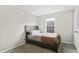 Bedroom with a dark wood bed frame, neutral walls, and a bright window at 294 Bent Stream Ln, Brownsburg, IN 46112
