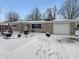 Charming single story home featuring stone exterior with attached garage and snow covered yard at 3025 E 6Th St, Anderson, IN 46012