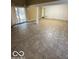 Open living room with tile flooring, brick wall, sliding door and neutral paint at 3302 E 42Nd St, Indianapolis, IN 46205