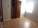 Well-lit bedroom featuring light laminate flooring, a window, and a closet for ample storage at 3534 Country Walk Dr, Indianapolis, IN 46227