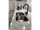 A close-up of a modern kitchen sink with a sleek faucet set into a white countertop at 3561 Bowen Pl, Indianapolis, IN 46221