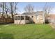 The house's backyard is spacious with lots of grass, a screen porch, and a wood fence at 4035 N Kenwood Ave, Indianapolis, IN 46208