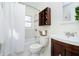 Bathroom with white tiled walls, wood vanity, and shower-tub combo at 4035 N Kenwood Ave, Indianapolis, IN 46208