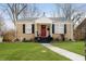 Charming single-story home featuring a landscaped lawn, red front door with wreath, and black shutters at 4035 N Kenwood Ave, Indianapolis, IN 46208