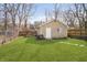 A backyard garage with a single door, small garden, and bench on a sunny day at 4035 N Kenwood Ave, Indianapolis, IN 46208