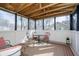 Enclosed porch featuring a vaulted ceiling, quaint seating, and an area rug at 4035 N Kenwood Ave, Indianapolis, IN 46208