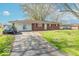 View of the front exterior showing the brick and siding home with a driveway and grassy area at 4113 Gambel Rd, Indianapolis, IN 46221