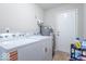A well-lit laundry room featuring a washer, dryer, water heater, and storage space at 4113 Gambel Rd, Indianapolis, IN 46221