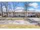 Two-story townhome showing a landscaped yard with mature trees and a sidewalk at 4307 Dahlia Ct, Indianapolis, IN 46220