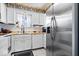 Traditional kitchen featuring white cabinetry, stainless steel refrigerator and a window that provides natural light at 4307 Dahlia Ct, Indianapolis, IN 46220