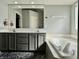 Well-lit bathroom with double vanity, soaking tub, and plush rug, creating a spa-like ambiance at 4309 Worchester Ct, Carmel, IN 46033