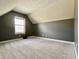 Attic bedroom offers privacy and comfort with sloped ceilings and neutral carpeting at 4309 Worchester Ct, Carmel, IN 46033