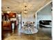 Open concept dining area with views into the kitchen and living room, featuring a modern pendant light and hardwood floors at 4309 Worchester Ct, Carmel, IN 46033
