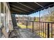 Inviting balcony with two chairs, black awning, and a metal railing overlooking trees and neighborhood at 4501 N Wheeling Ave # 6A - 201, Muncie, IN 47304