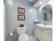 Cozy bathroom features a toilet and a vanity with an oval mirror, complemented by light blue walls at 4501 N Wheeling Ave # 6A - 201, Muncie, IN 47304