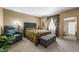 Comfortable bedroom features a gray upholstered bed and ottoman, complementing tropical accents at 4501 N Wheeling Ave # 6A - 201, Muncie, IN 47304