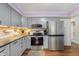 Well-lit kitchen features gray cabinets, stainless steel appliances, stone countertops, and wood flooring at 4501 N Wheeling Ave # 6A - 201, Muncie, IN 47304
