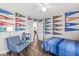 Bright bedroom with sporty decor, featuring school pennants, wood floors, a ceiling fan, and an inviting sitting area at 481 Autumn Springs Ct, Avon, IN 46123