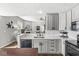 Open kitchen featuring stainless appliances, grey cabinets, island seating and hardwood floors at 481 Autumn Springs Ct, Avon, IN 46123