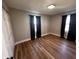 Cozy bedroom featuring hardwood floors, neutral wall color, and window with black curtains at 5061 N 200 W, Columbus, IN 47201