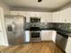 Well-appointed kitchen with stainless steel appliances, white cabinetry, a modern backsplash, and wood flooring at 518 Waterford Way, Danville, IN 46122