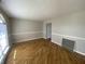 Bright living room with beautiful hardwood floors, a large arched window, and neutral wall color at 518 Waterford Way, Danville, IN 46122